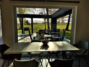 a dining room with a table and chairs and a large window at Country house Greenfields in Gospić