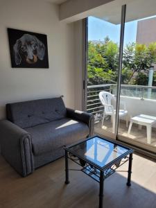 a living room with a couch and a glass table at Hermoso departamento en Flores! in Buenos Aires