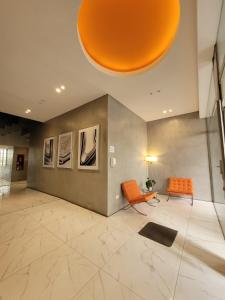 a lobby with an orange chair and a table at Hermoso departamento en Flores! in Buenos Aires