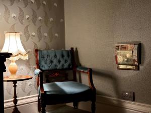 a blue chair in a room with a lamp at The Buckley Arms in Dinas Mawddwy