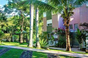 une maison avec des palmiers devant dans l'établissement Ilhabela - Praia do Curral - Casa em condomínio, à Ilhabela