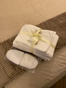 una toalla y un par de sandalias en una cama en Domus Relax, en Pietrelcina