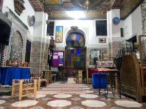 Habitación grande con una mezquita con mesa y sillas. en Riad Abqari Youssefi en Fez