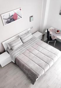 biała sypialnia z dużym łóżkiem i stołem w obiekcie Casa Vacanza Al Massimo w mieście Palermo