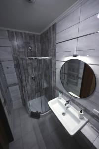 ein Bad mit einer Dusche, einem Waschbecken und einem Spiegel in der Unterkunft Apartmány PARK in Klášterec nad Ohří