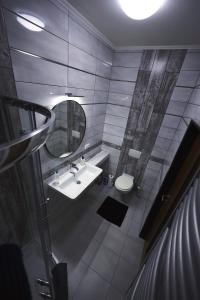ein Badezimmer mit einem Waschbecken, einem Spiegel und einem WC in der Unterkunft Apartmány PARK in Klášterec nad Ohří