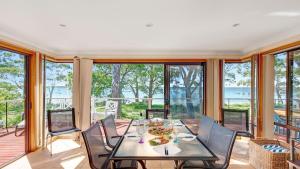 a dining room with a table and chairs at Tradewinds in Callala Bay