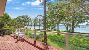 a deck with a bench and a view of the water at Tradewinds in Callala Bay