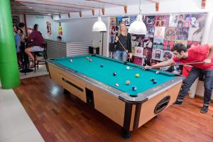 um homem a jogar bilhar num quarto em Milhouse Hostel Hipo em Buenos Aires