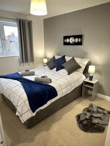 Schlafzimmer mit einem großen Bett mit blauer und weißer Bettwäsche in der Unterkunft 6 Stephenson Way in York
