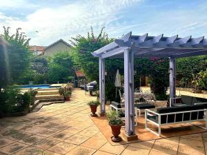 una pérgola con bancos y una piscina en un patio en Villa Charles - île de Gorée, en Gorée