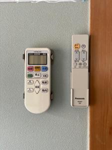 un mando a distancia en una pared junto a una puerta en 日久の宿 en Kokubunji