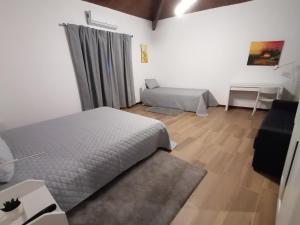 um quarto com 2 camas, uma mesa e um sofá em Casa d'Amêndoa em Felgar