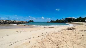 una spiaggia sabbiosa con l'oceano sullo sfondo di Allan Villa a Midigama East