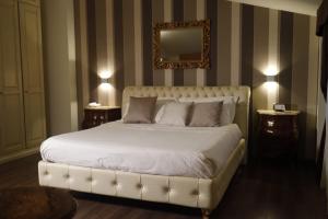 una camera da letto con un grande letto bianco e uno specchio di Virginia Resort & Spa - Adults Only ad Avellino