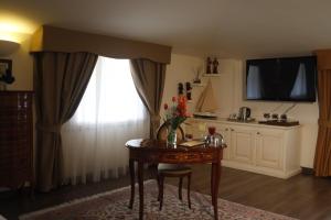 Una habitación con una mesa con un jarrón de flores. en Virginia Resort & Spa - Adults Only, en Avellino