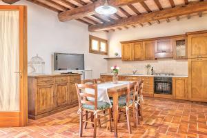 eine Küche mit einem Tisch und Stühlen sowie einem TV in der Unterkunft Borgo del Faggio - Case Vacanza in Montepulciano