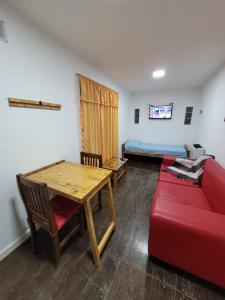Habitación con mesa, sofá y cama en Departamento Desire en Puerto Deseado