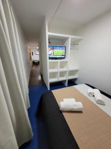 Habitación con TV y 2 toallas en una cama. en Departamento Desire en Puerto Deseado