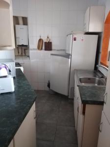 a kitchen with a white refrigerator and a sink at Vista al Mar Departamento - Edificio Acapulco in Viña del Mar +10 photos