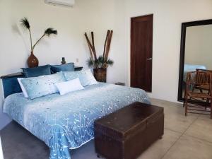 Un dormitorio con una cama azul con un baúl. en Litibu Suites Beach House, en Higuera Blanca