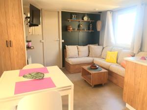 uma sala de estar com um sofá e uma mesa em MH Luxury Eden Mar Estang Plage 100m 2TV 2 Sdb Baby confort Plus em Canet-en-Roussillon