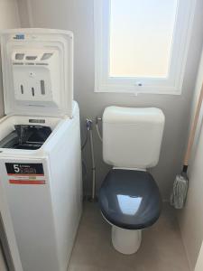 a small bathroom with a toilet with a hair dryer at MH Luxury Eden Mar Estang Plage 100m 2TV 2 Sdb Baby confort Plus in Canet-en-Roussillon
