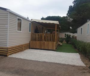 a mobile home with a porch with a deck at MH Luxury Eden Mar Estang Plage 100m 2TV 2 Sdb Baby confort Plus in Canet-en-Roussillon