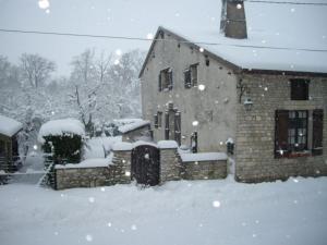 a house covered in snow in a yard at Charmante maison historique avec jardin à Vadelaincourt - Charme, cheminée, et sérénité - FR-1-585-67 in Vadelaincourt