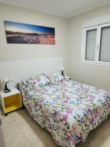 a bedroom with a bed with a floral bedspread at Casa Marta. in Granadilla de Abona