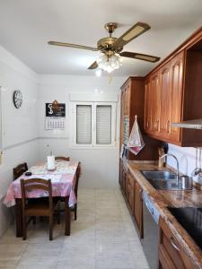 a kitchen with a table and a ceiling fan at Casa Marta. in Granadilla de Abona