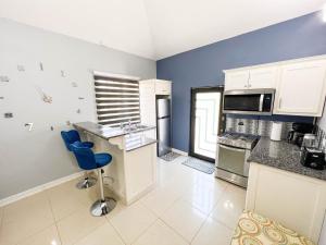 uma cozinha com armários brancos e uma parede azul em Pineridge Hideaway 1 Bedroom Apartment #2 em Arouca