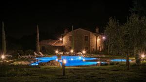 a house with a swimming pool at night at Borgo del Faggio - Case Vacanza in Montepulciano
