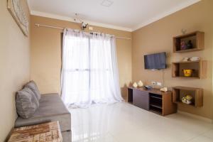 ein Wohnzimmer mit großem Fenster und einer Couch in der Unterkunft Flat n6 Porto de Galinhas c Piscina in Porto De Galinhas