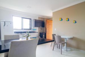 eine Küche und ein Esszimmer mit Tisch und Stühlen in der Unterkunft Flat n6 Porto de Galinhas c Piscina in Porto De Galinhas