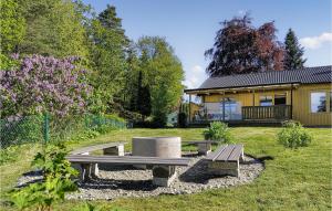 a park bench in front of a house at Beautiful Home In Hllingsj With Lake View in Hällingsjö