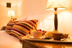 a tray with coffee cups and fruit on a bed at Cielo Arriba Casa in Humahuaca