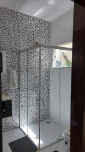 a bathroom with a glass shower and a toilet at Quarto Aconchegante Completo in Cruzeiro