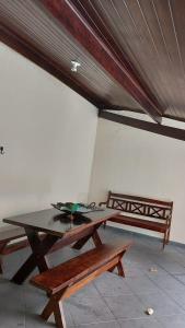 a picnic table and a bench in a room at Quarto Aconchegante Completo in Cruzeiro