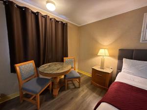 a hotel room with a bed and a table and chairs at Skyline Inn in Atlantic City