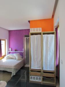 ein Schlafzimmer mit einem Bett und einer orangefarbenen und violetten Wand in der Unterkunft La Terrazza sul Mare in Aci Castello