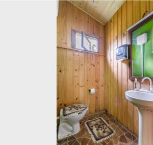 a wooden bathroom with a toilet and a sink at Casa de Campo Vó Almerinda in Urubici
