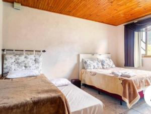 een slaapkamer met 2 bedden en een raam bij Casa de Campo Vó Almerinda in Urubici