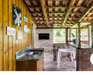 an outdoor kitchen with a sink and a counter at Casa de Campo Vó Almerinda in Urubici