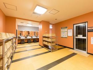 Habitación con paredes de color naranja y peluquería. en APA Hotel & Resort Joetsu Myoko, en Myoko