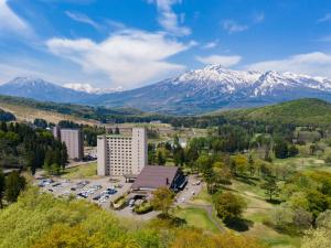una vista aerea di un hotel con le montagne sullo sfondo di APA Hotel & Resort Joetsu Myoko a Myoko