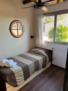 Habitación pequeña con cama y ventana en Cálido departamento en Tigre en El Talar de Pacheco