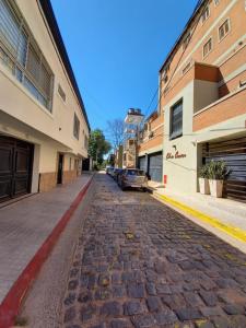 una strada acciottolata in una città con edifici di Apart Checatu I a Corrientes