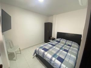 a bedroom with a bed and a chair in it at Cómodo apto 203 muy cerca a CENTRO COMERCIAL UNICENTRO CUCUTA in Cúcuta
