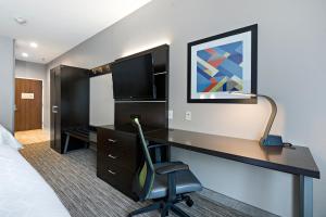 een hotelkamer met een bureau en een stoel bij Holiday Inn Express Hotel & Suites Kilgore North, an IHG Hotel in Kilgore